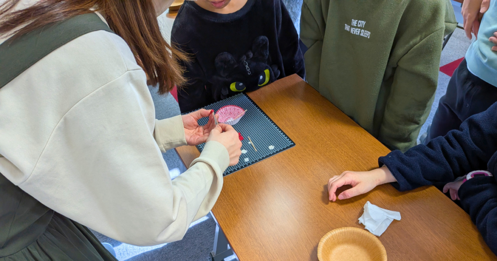 【ワークショップ実施報告】2025年12月14日（日）こびとの農園×にこにこ塾「イチゴの小さなクリスマスリース」 つまみ細工の実演